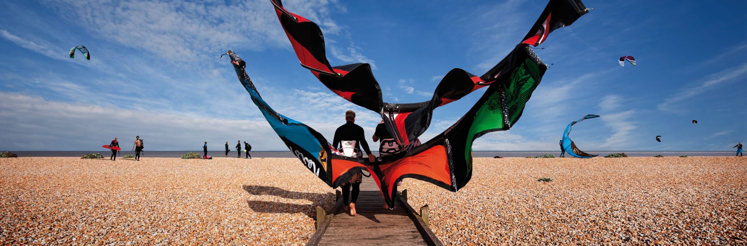 Paragliders walking on to the beach